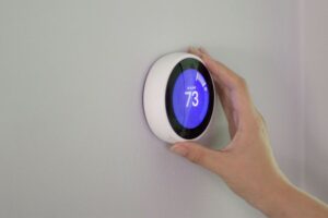 someone holding a thermostat